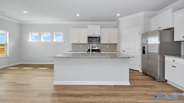 kitchen with stainless steel appliances, white cabinetry, and a center island with sink