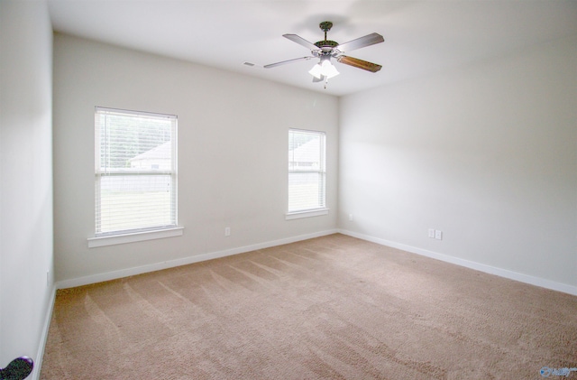 spare room featuring light carpet and ceiling fan