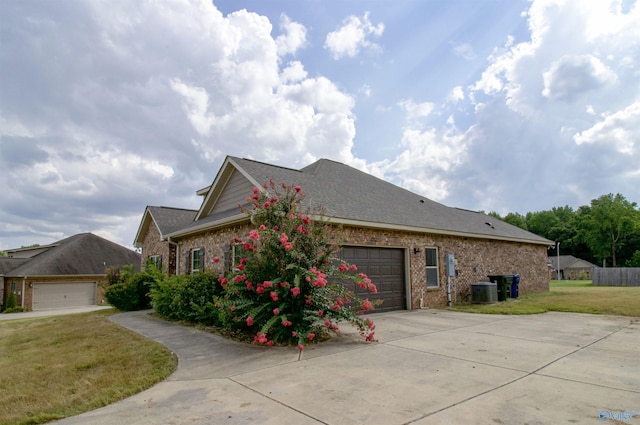 view of home's exterior featuring cooling unit, a yard, and a garage