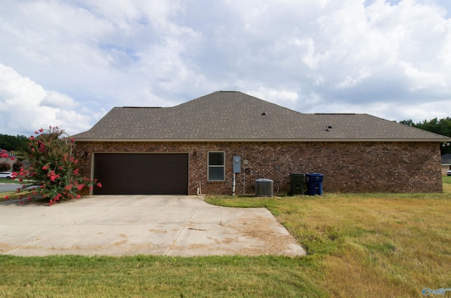 view of property exterior featuring central AC unit, a garage, and a lawn