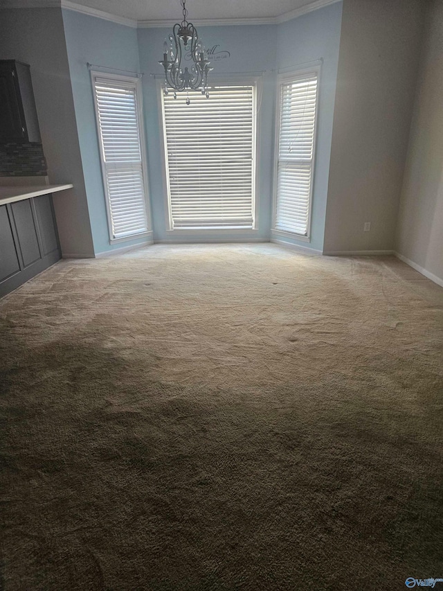 unfurnished dining area featuring ornamental molding, carpet, and a notable chandelier