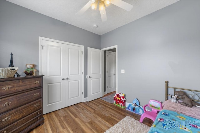 bedroom with a closet, ceiling fan, and light hardwood / wood-style flooring