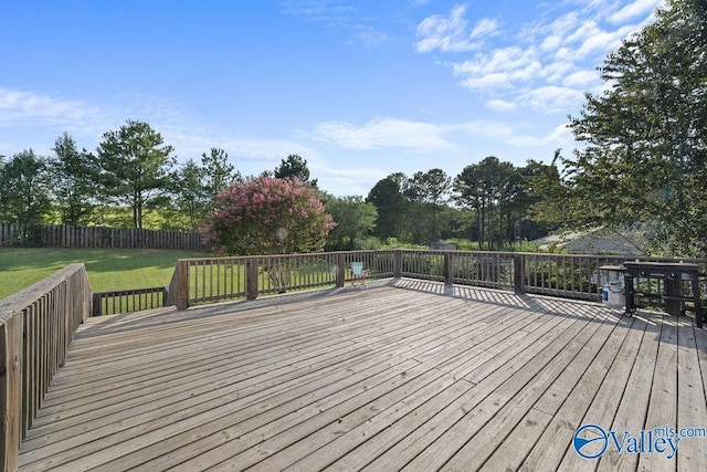 wooden terrace featuring a yard and a grill