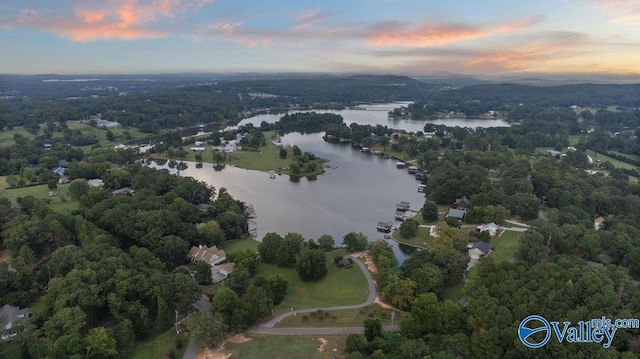 aerial view at dusk featuring a water view