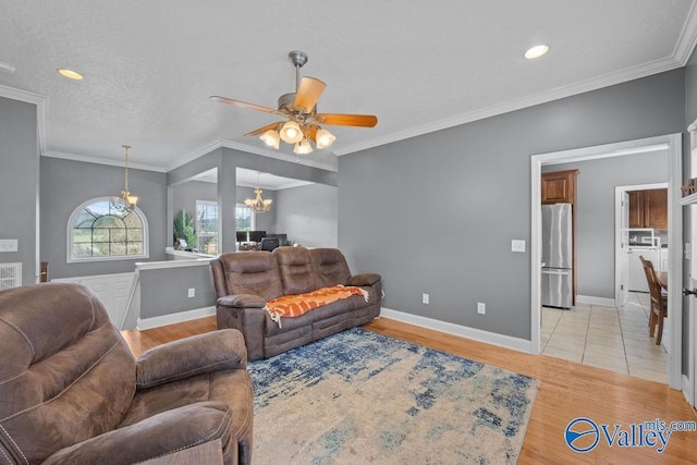 living room with crown molding, ceiling fan with notable chandelier, and light wood-type flooring