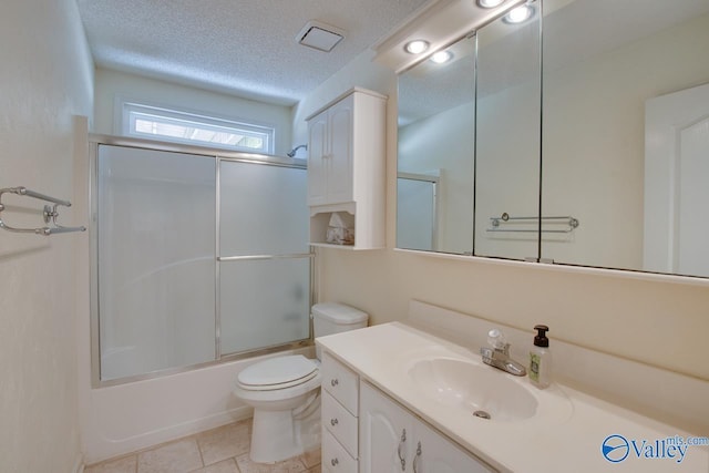 full bathroom with toilet, enclosed tub / shower combo, tile patterned floors, a textured ceiling, and vanity