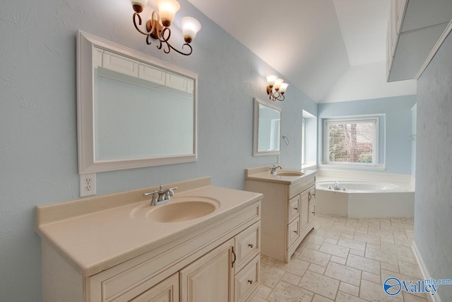 full bath featuring a garden tub, two vanities, a sink, and stone tile floors