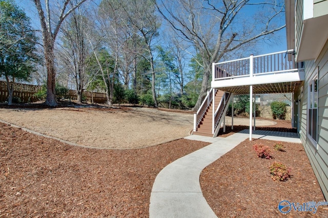 view of yard featuring stairs, fence, and a wooden deck