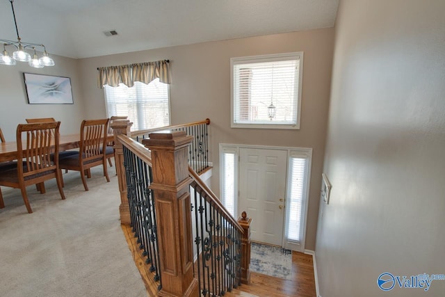 entrance foyer with light carpet, high vaulted ceiling, and visible vents