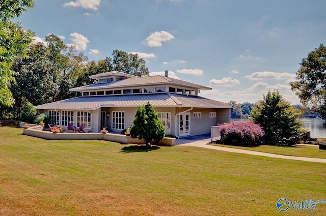 view of front of property featuring metal roof, a patio area, a front lawn, and french doors