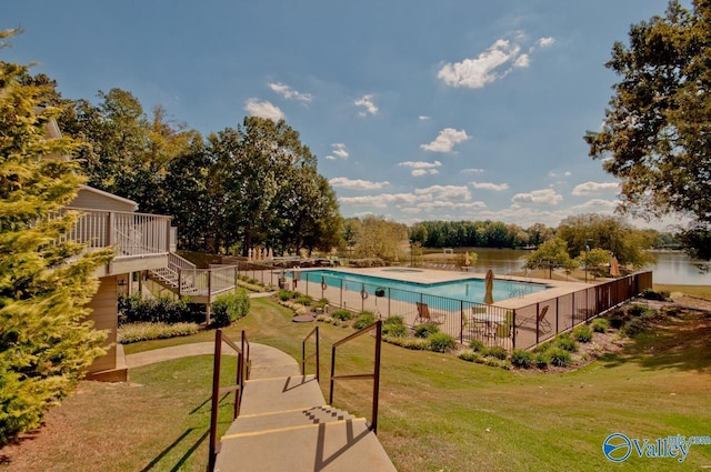 pool featuring stairs, fence, and a lawn