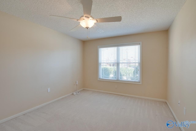 empty room featuring ceiling fan, a textured ceiling, baseboards, and carpet flooring