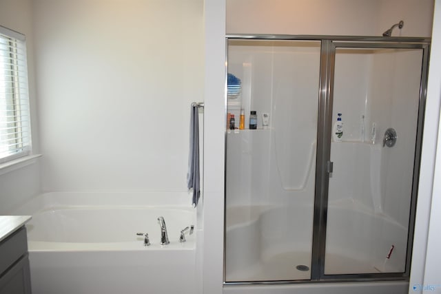 bathroom with a stall shower, a wealth of natural light, vanity, and a bath