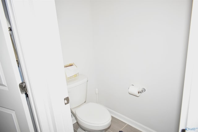 bathroom featuring tile patterned flooring, toilet, and baseboards