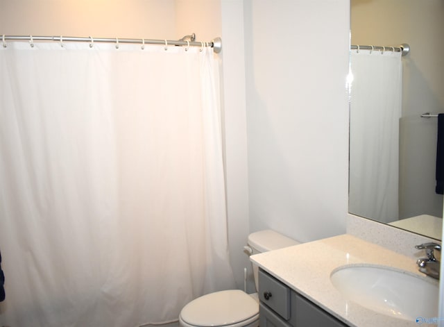 bathroom featuring toilet, a shower with shower curtain, and vanity