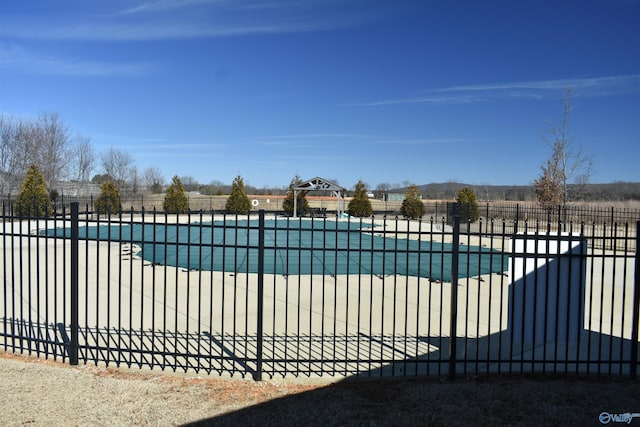 community pool with a patio and fence