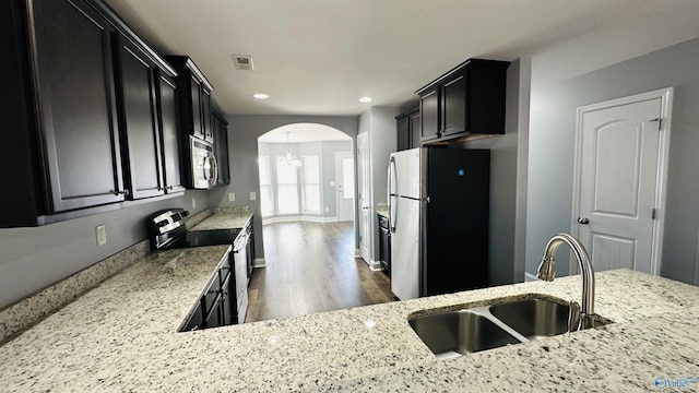 kitchen featuring appliances with stainless steel finishes, sink, and light stone counters