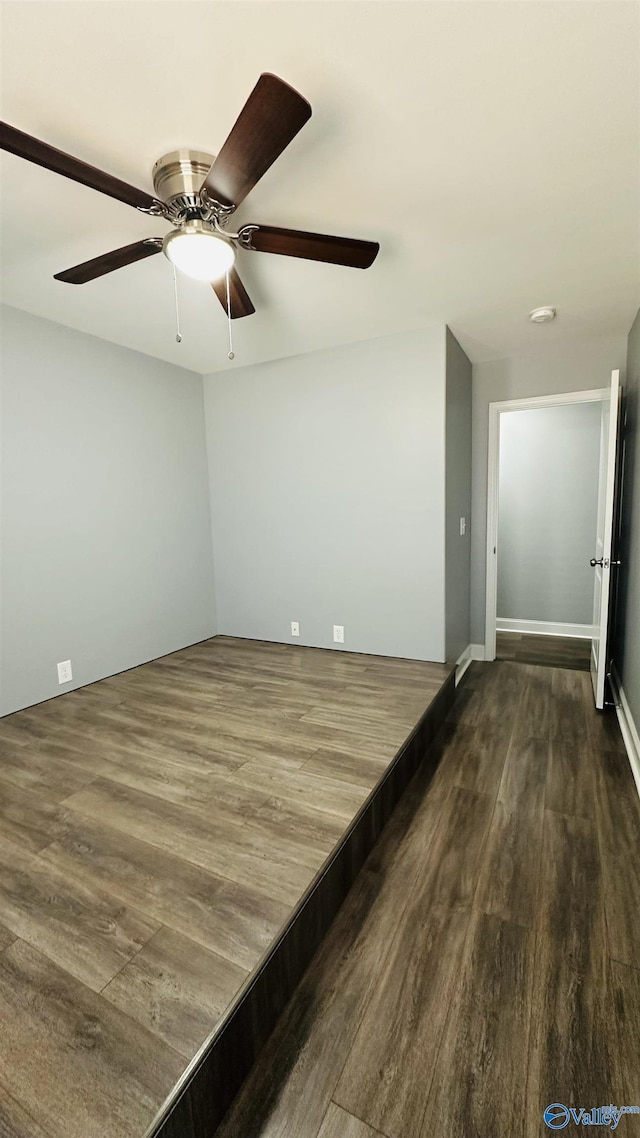 unfurnished room featuring ceiling fan and dark hardwood / wood-style flooring