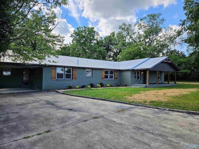 ranch-style home featuring a front lawn and a carport