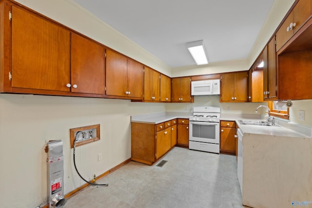 113 Gordon Dr, Athens, AL 35611 - kitchen featuring white appliances, a sink, brown cabinetry, and light countertops