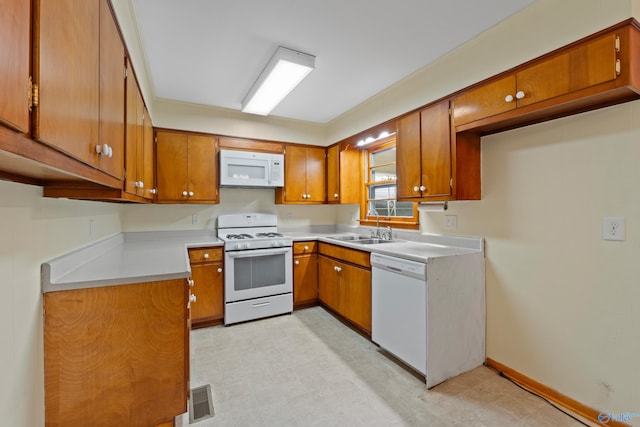 113 Gordon Dr, Athens, AL 35611 - kitchen with white appliances, brown cabinets, and a sink