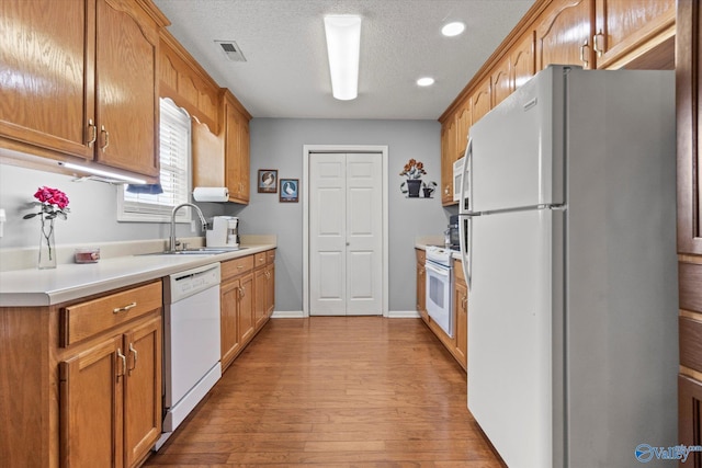 194 Bonaire Dr, Huntsville, AL 35811 - kitchen featuring white appliances, a sink, light countertops, light wood-style floors, and recessed lighting