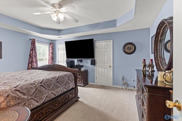 194 Bonaire Dr, Huntsville, AL 35811 - bedroom featuring light carpet, baseboards, a textured ceiling, a tray ceiling, and ceiling fan