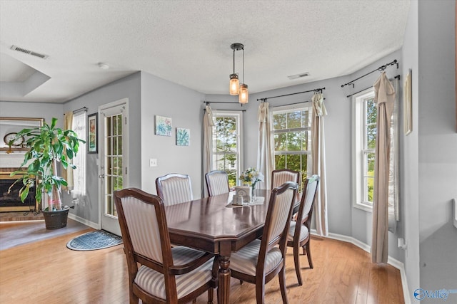194 Bonaire Dr, Huntsville, AL 35811 - dining space with light wood-style flooring, baseboards, and a textured ceiling