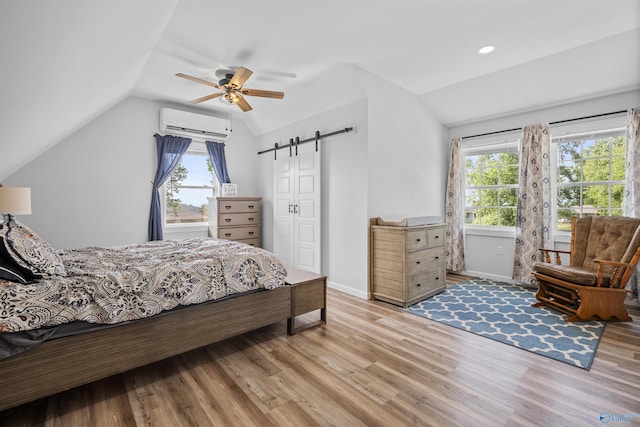 331 Ayers Cir, Grant, AL 35747 - bedroom with lofted ceiling, a wall mounted air conditioner, a barn door, light wood-style flooring, and multiple windows