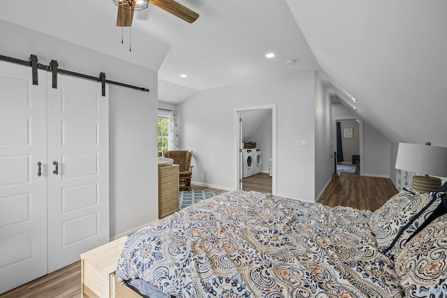 331 Ayers Cir, Grant, AL 35747 - bedroom with washer and dryer, vaulted ceiling, a barn door, wood finished floors, and recessed lighting