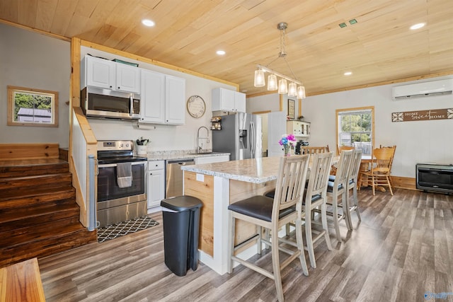 331 Ayers Cir, Grant, AL 35747 - kitchen with appliances with stainless steel finishes, wooden ceiling, a wall mounted AC, wood finished floors, and a center island