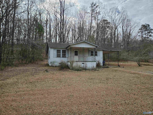 view of front of house featuring driveway, covered porch, a carport, and a front yard