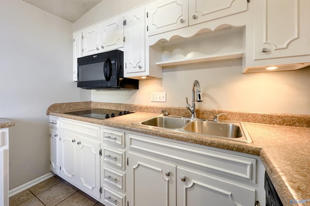 kitchen with light tile patterned flooring, sink, white cabinetry, and black appliances