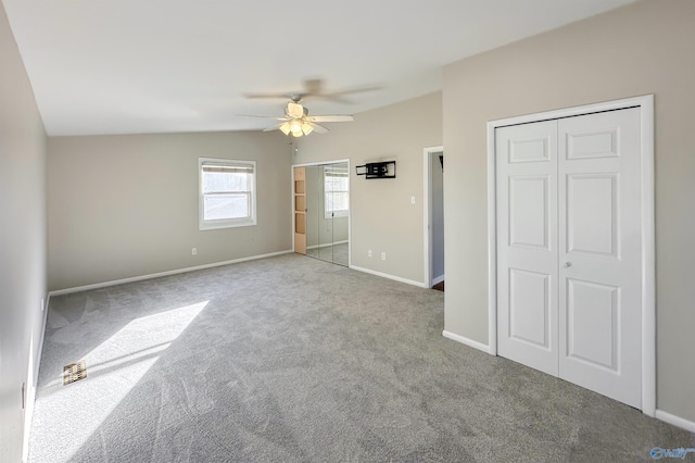 unfurnished bedroom with light colored carpet, vaulted ceiling, and ceiling fan