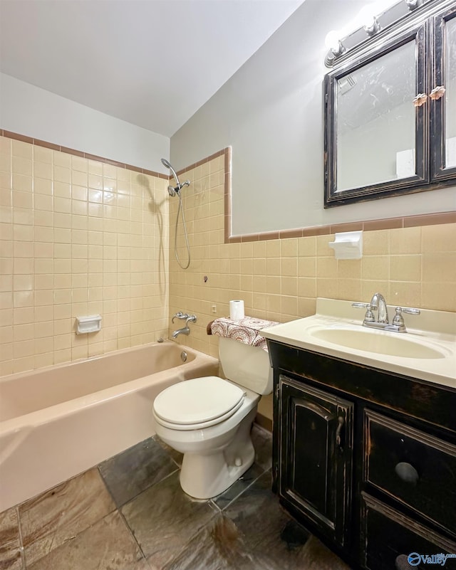 full bathroom with vanity, toilet, tile walls, and tiled shower / bath