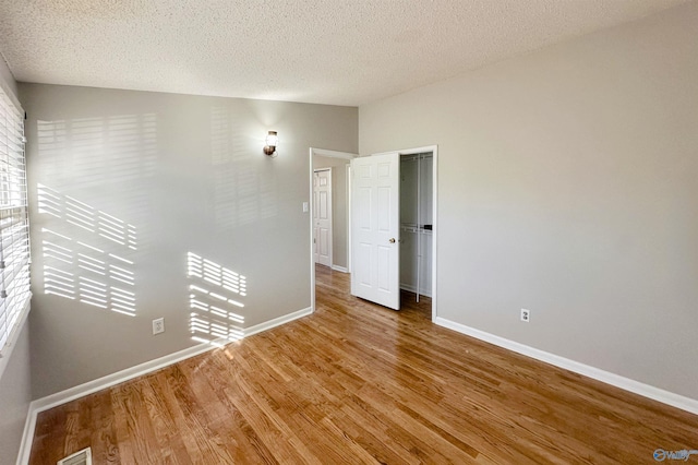 spare room featuring hardwood / wood-style flooring and a textured ceiling