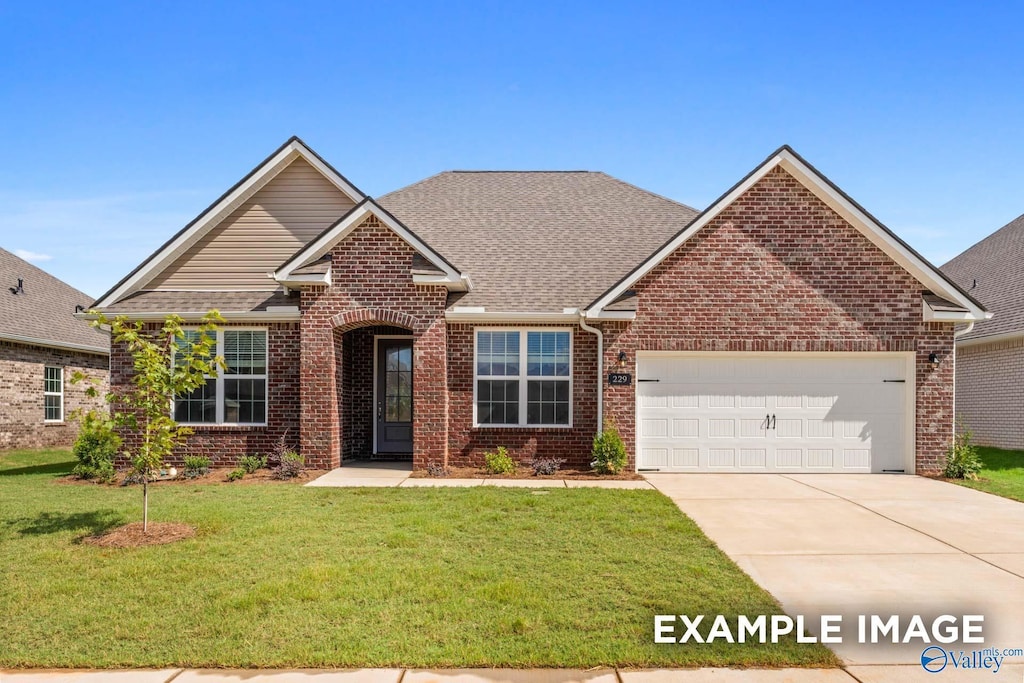 view of front of house with brick siding, a front yard, driveway, and a garage