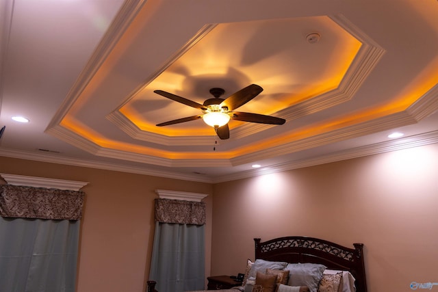 bedroom featuring ornamental molding, ceiling fan, and a tray ceiling