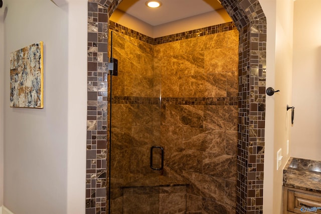 bathroom with a shower with shower door and vanity