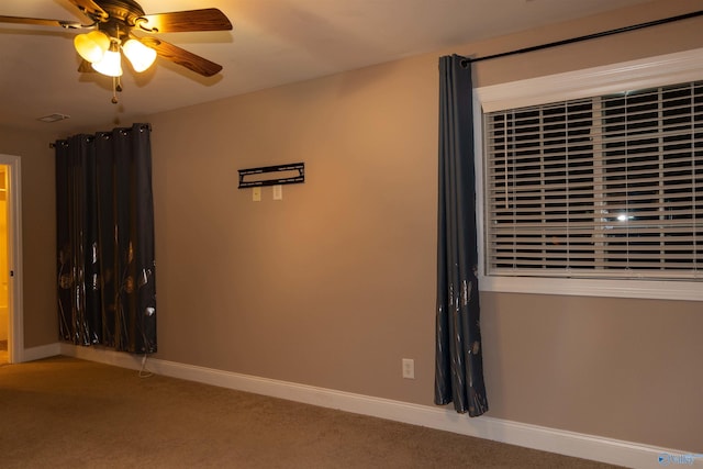 carpeted spare room with ceiling fan