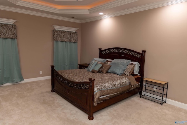 carpeted bedroom featuring ornamental molding and a tray ceiling