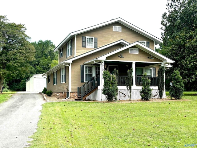 view of front of home featuring an outdoor structure, a garage, a porch, and a front lawn