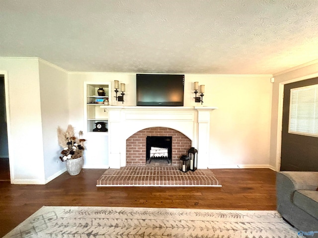 living room with a textured ceiling, wood-type flooring, a brick fireplace, and crown molding