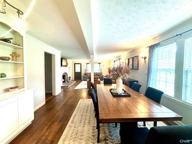 dining space with dark wood-type flooring, a textured ceiling, crown molding, and plenty of natural light