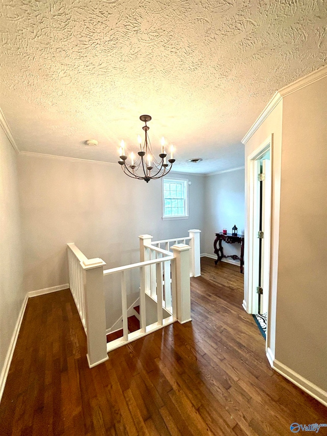 interior space featuring an inviting chandelier, a textured ceiling, crown molding, and hardwood / wood-style floors