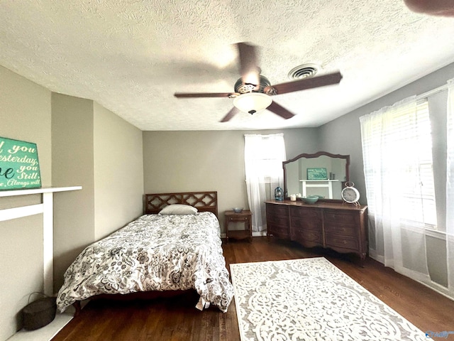 bedroom featuring a textured ceiling, dark hardwood / wood-style flooring, and ceiling fan