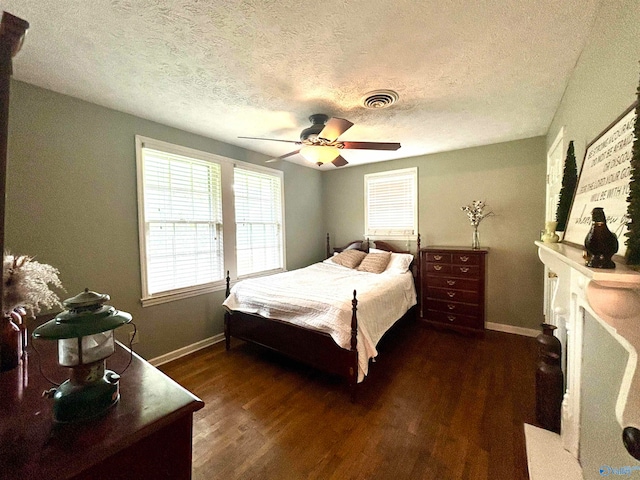 bedroom featuring dark wood-type flooring, a textured ceiling, and ceiling fan