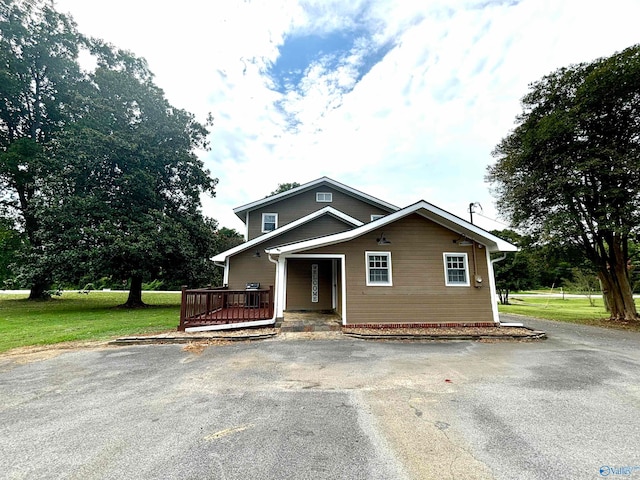 view of front of house featuring a wooden deck and a front lawn