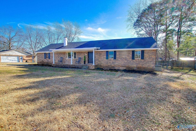 single story home with a garage, an outbuilding, and a front lawn