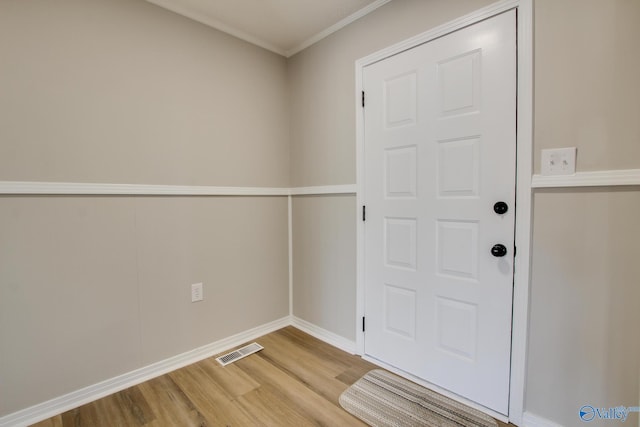 doorway featuring hardwood / wood-style flooring and ornamental molding